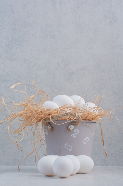 Foto gratuita huevos blancos frescos en balde sobre fondo de mármol.