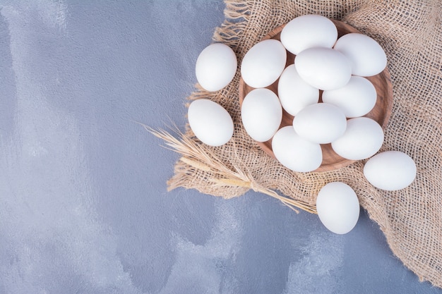 Huevos blancos sobre un trozo de arpillera.