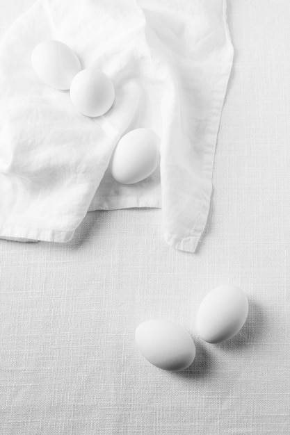 Huevos blancos de vista superior con toalla de cocina