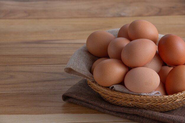 Los huevos en la canasta se colocan en el piso de madera.