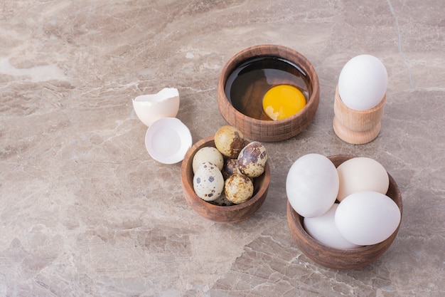 Huevos, cáscaras de huevo y yema de huevo en una taza de madera