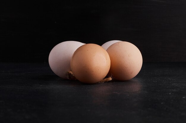 Huevos en el centro en espacio negro.