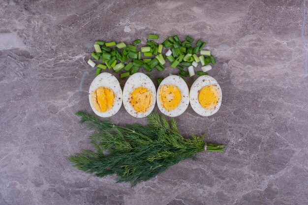 Foto gratuita huevos cocidos con cebolla picada y un manojo de eneldo