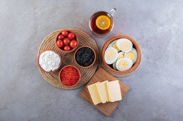 Huevos cocidos en rodajas con especias colocados sobre la mesa de piedra.