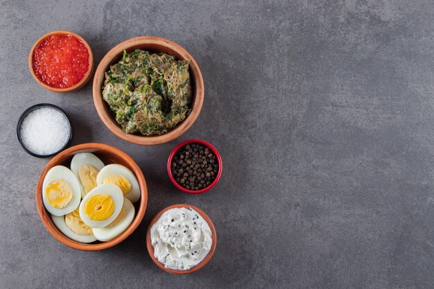 Huevos cocidos con sal y caviar colocados sobre un fondo de piedra.