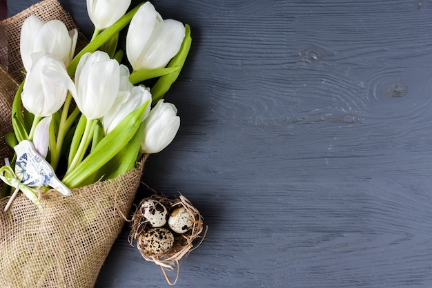 Foto gratuita huevos de codorniz cerca de tulipanes blancos