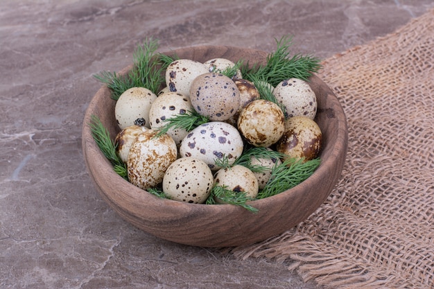 Huevos de codorniz con hierbas picadas en una taza de madera