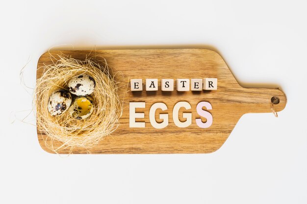 Huevos de codorniz de Pascua en el tablero de madera