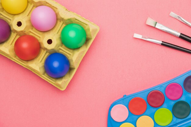Huevos de colores y herramientas de pintura.