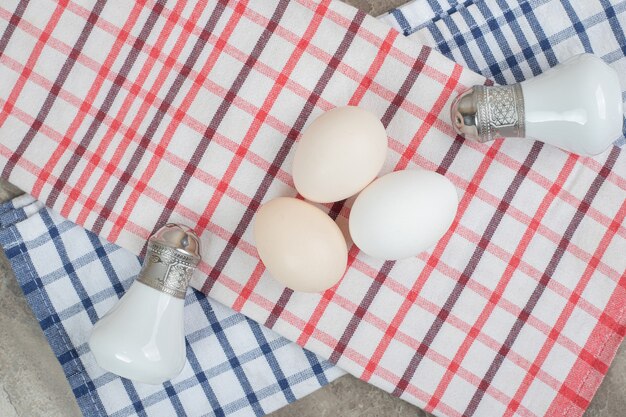 Huevos crudos y especias con mantel sobre superficie de mármol. Foto de alta calidad