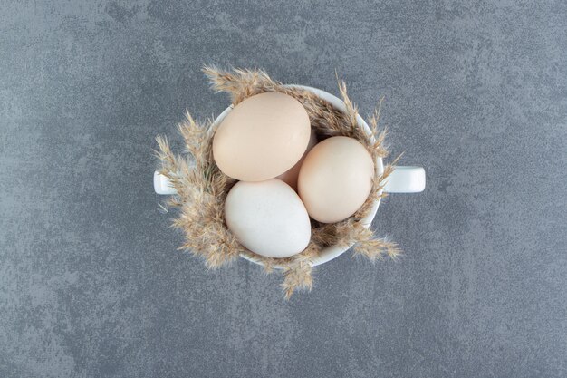 Huevos crudos orgánicos en taza blanca.