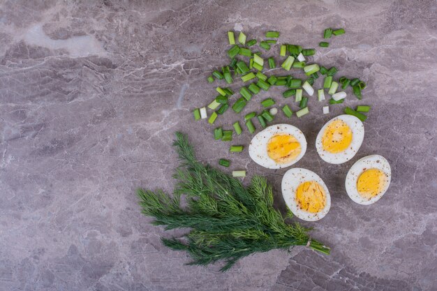 Huevos duros con hierbas sobre mármol.