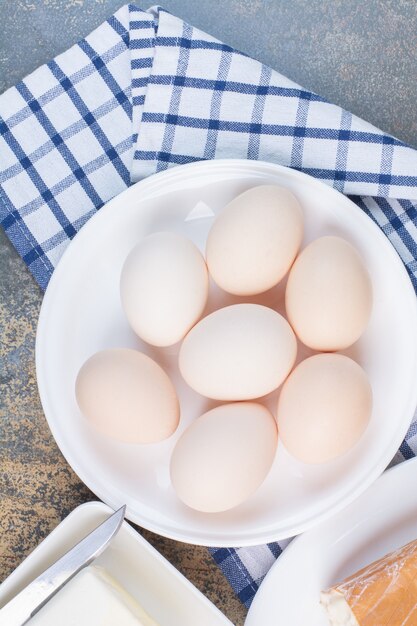 Huevos duros en un plato blanco con mantel.