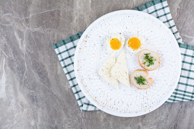 Huevos duros sabrosos con especias y pan sobre mantel. Foto de alta calidad