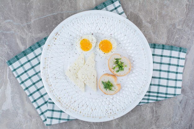 Huevos duros sabrosos con especias y pan sobre mantel. Foto de alta calidad