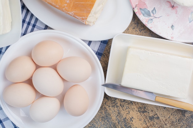 Foto gratuita huevos duros y varios quesos en platos.