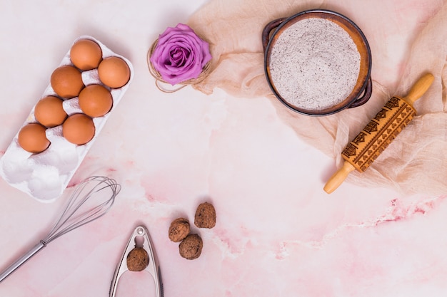 Huevos en estante con flores y utensilios de cocina.