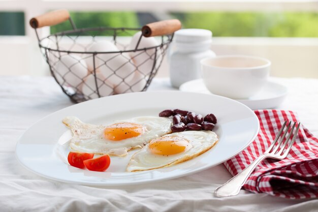 Huevos fritos en un plato con un tenedor