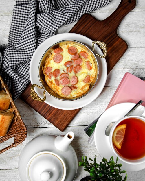 Huevos fritos con salchichas en una sartén de aluminio