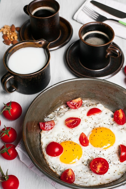 Huevos fritos con tomate y café.