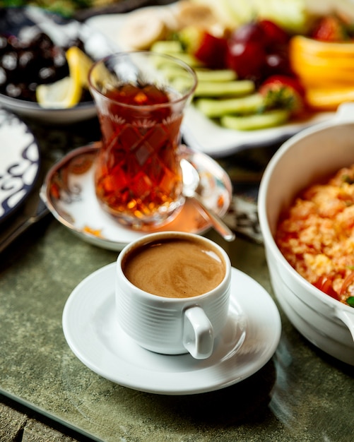 Huevos fritos con tomate y hierbas con té negro y café.