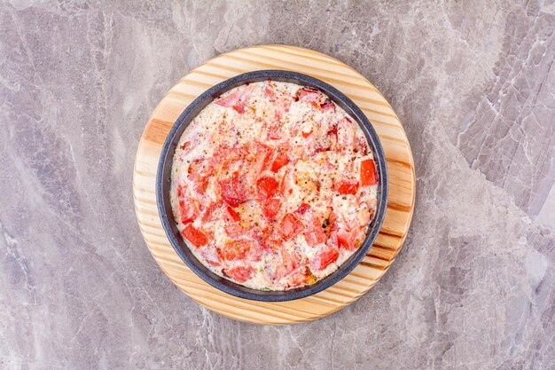 Huevos fritos con tomate en sartén oscura. Foto de alta calidad