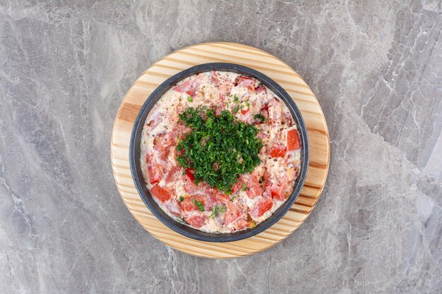 Huevos fritos con tomate en sartén oscura con verduras. Foto de alta calidad