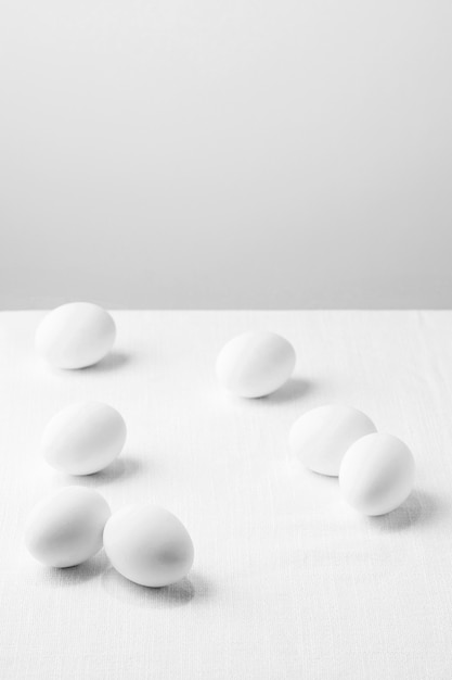 Huevos de gallina blanca de alto ángulo en la mesa con espacio de copia