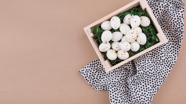 Foto gratuita huevos de gallina blanca en caja de madera sobre mesa