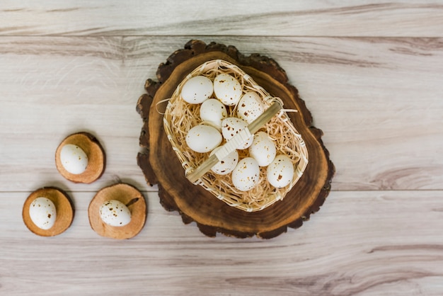 Huevos de gallina blanca en canasta en mesa de madera