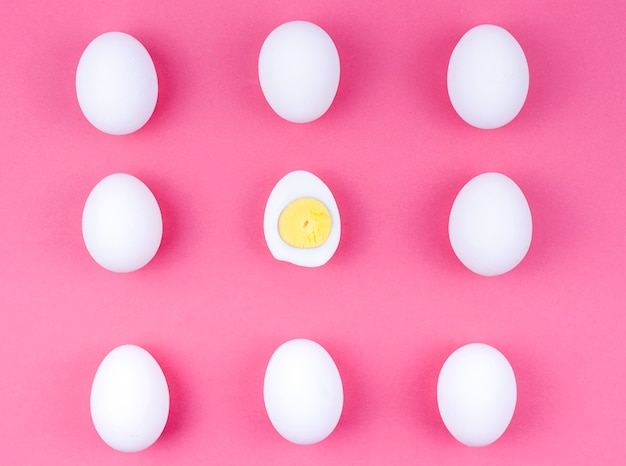 Huevos de gallina blanca con huevo cocido en mesa