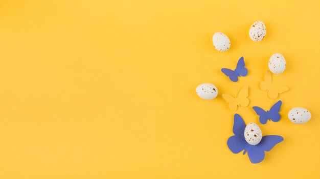 Huevos de gallina blanca con mariposas de papel.