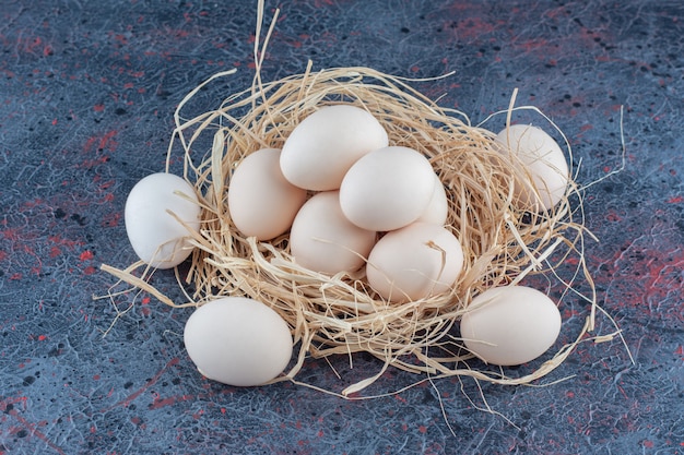 Huevos de gallina blancos y marrones frescos con heno