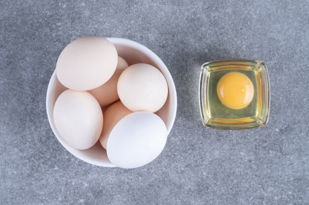 Huevos de gallina cruda blanca fresca en una placa blanca.