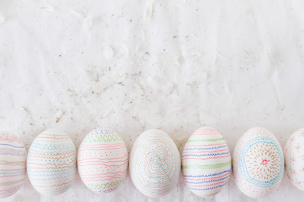 Foto gratuita huevos de gallina con estampados cerca de las plumas sobre textil