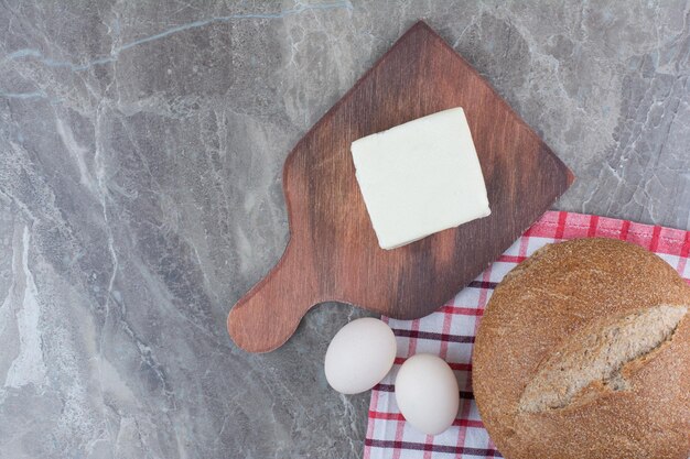 Huevos de gallina frescos con pan sobre mantel. Foto de alta calidad