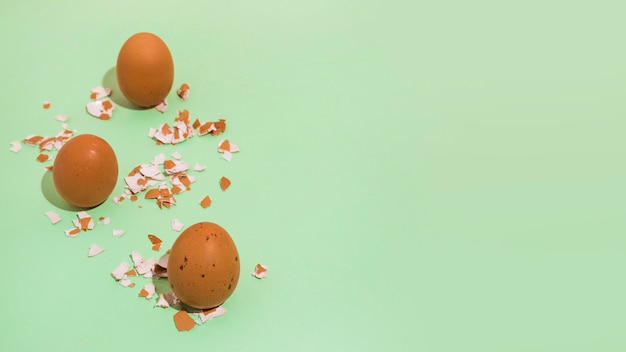 Huevos de gallina marrón con cáscara rota en mesa verde