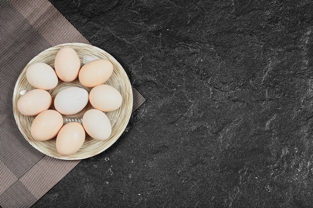 Huevos de gallina en plato de cerámica. Vista desde arriba.