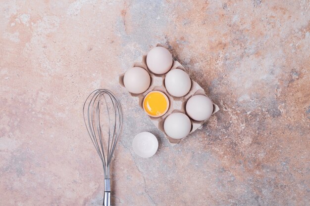 Huevos de gallina en recipiente con bigote.