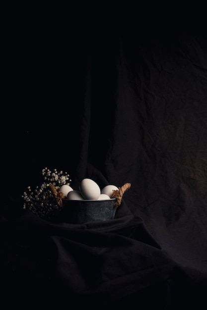 Huevos de gallina en un tazón cerca de la planta