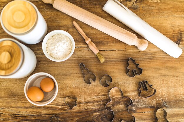 Huevos, harina, rodillo y moldes para galletas.