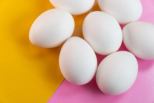 Huevos en la mesa amarilla y rosa.