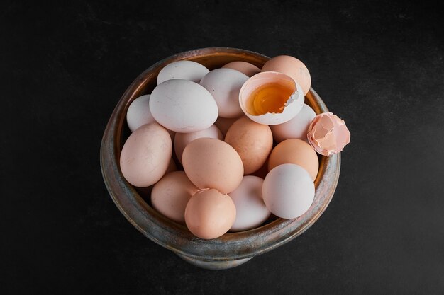Huevos orgánicos y cáscaras de huevo en un recipiente metálico.