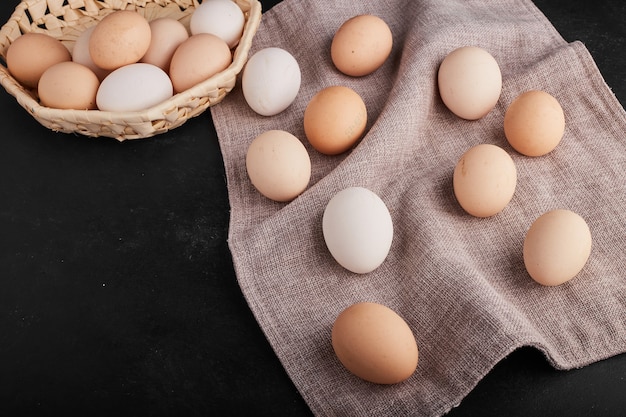 Huevos orgánicos sobre papel de cocina y en taza de bambú.