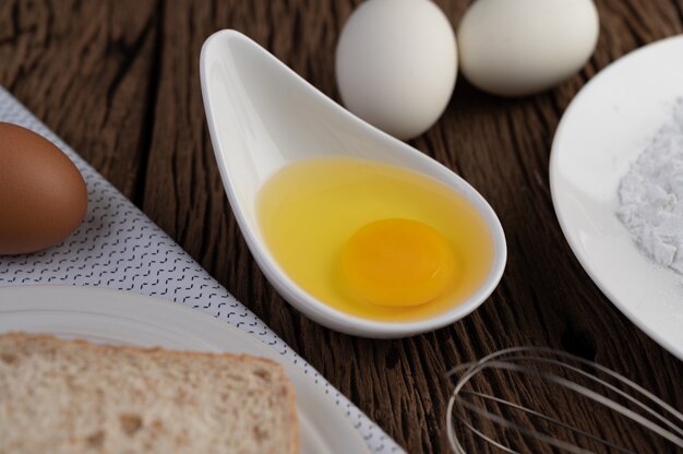 Huevos, pan, harina de tapioca y un batidor de huevo, ingredientes utilizados en panadería.