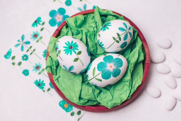 Huevos de Pascua con adornos florales colocados en bandeja