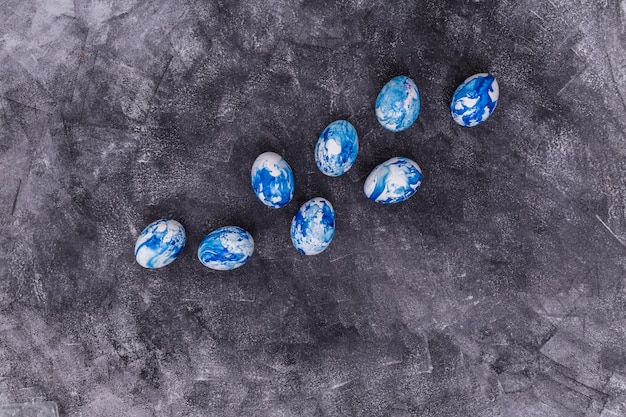 Foto gratuita huevos de pascua azules esparcidos sobre mesa gris