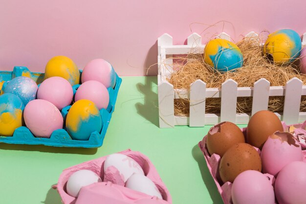 Huevos de Pascua en bastidores y en heno en mesa