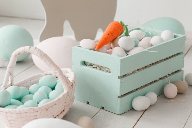 Huevos de Pascua blancos en caja de madera pintada.