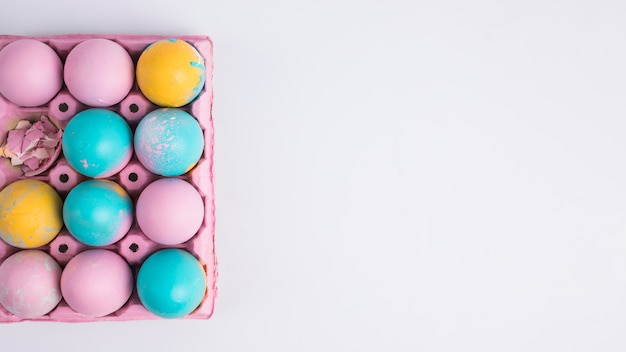 Foto gratuita huevos de pascua brillantes en contenedor rosa